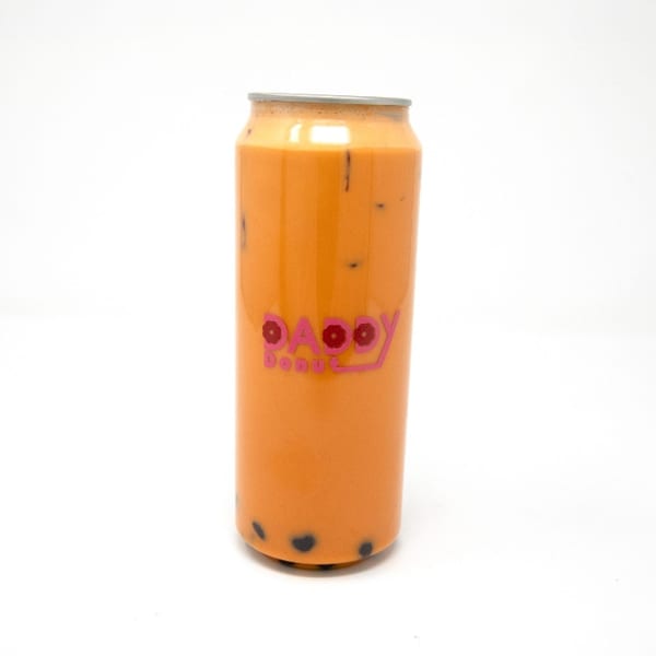Daddy Donut's orange Thai tea with boba pearls in a clear can against a white background.