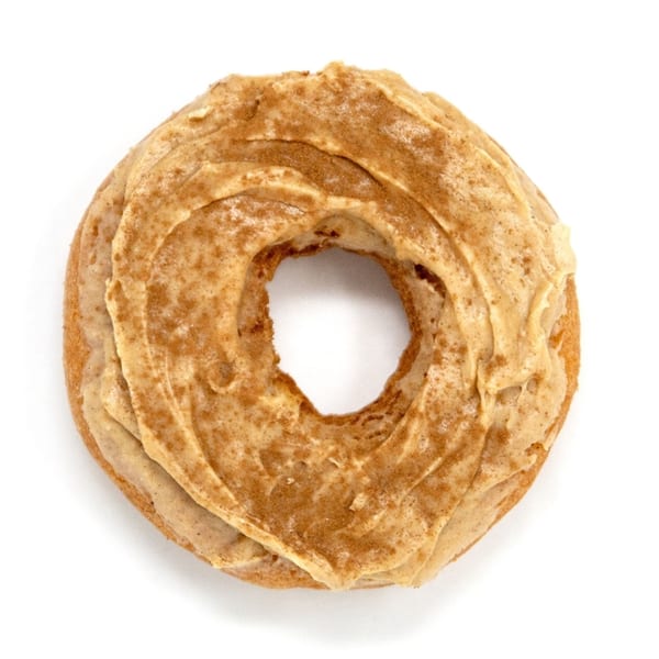 A Daddy Donut cinnamon sugar donut with light brown frosting and a dusting of cinnamon.