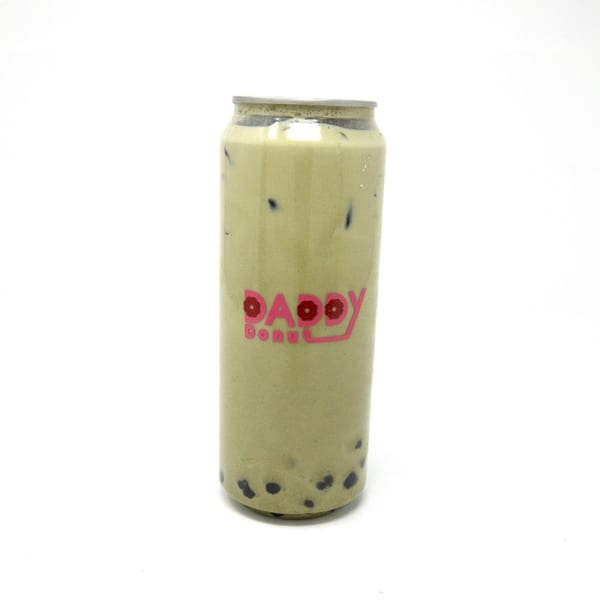 A Daddy Donut matcha boba tea with ice in a clear can against a white background.