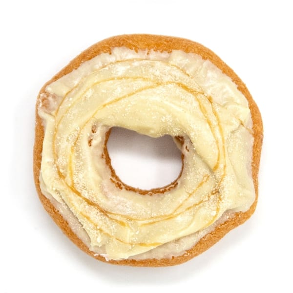 A Daddy Donut with white frosting and a golden drizzle, dusted with powdered sugar.
